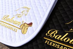 White and black saddle pad with gold embroidery Baloun® logo White and black saddle pad with gold embroidery Baloun® logo